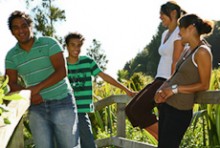 A group of four teenagers standing on a deck