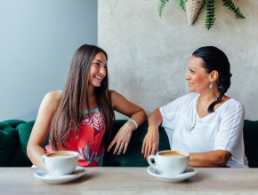 A mother and daughter talking on a couch