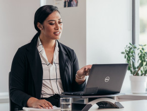 Woman negotiating looking into a laptop with her hand up 