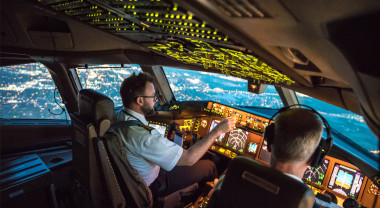 Two male pilots in the cockpit flying an aeroplane