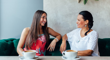 A mother and daughter talking on a couch