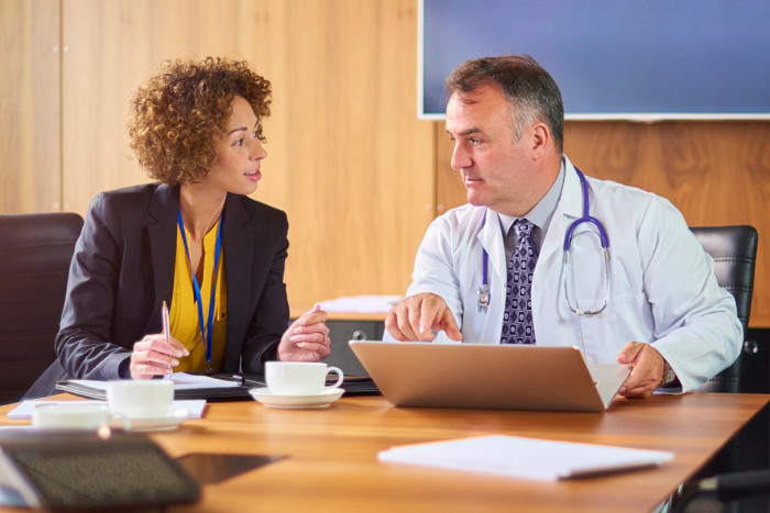 A female health services manager talking a male doctor