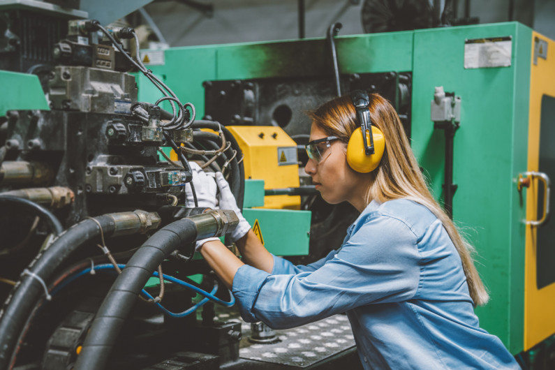 A female engineer repairing a production line machine