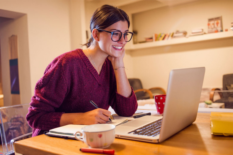 A woman sitting at a computer applying for jobs online