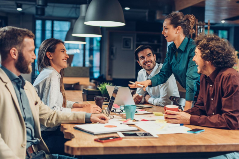 A woman uses her communication management skills when talking to co-workers 