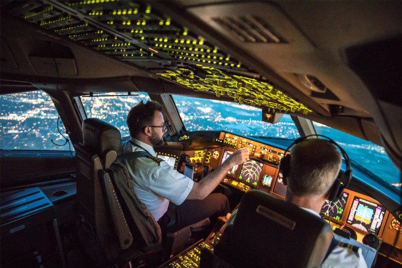 Two male pilots in the cockpit flying an aeroplane