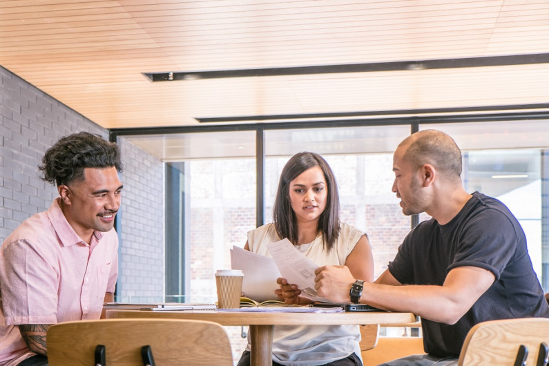 A man and woman interview a candidate at an office table