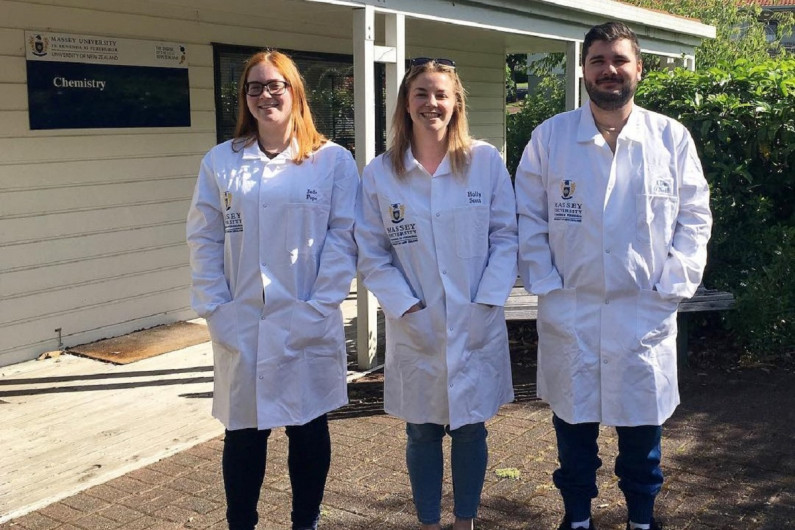 Holly Scott (centre) and colleagues standing in white coats outside a building