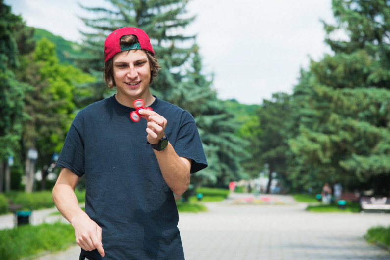 A young person with autism plays with a fidget spinner