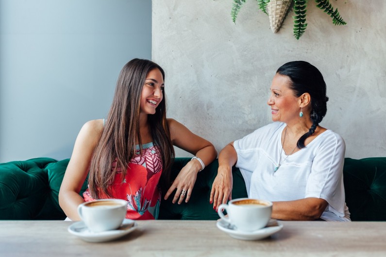 A mother and daughter talking on a couch