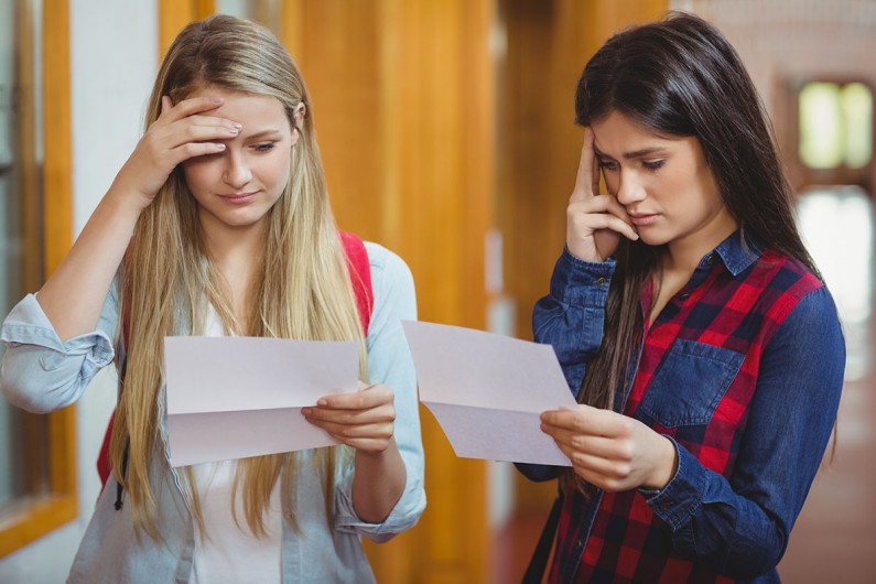 Two learners looking at their exam results