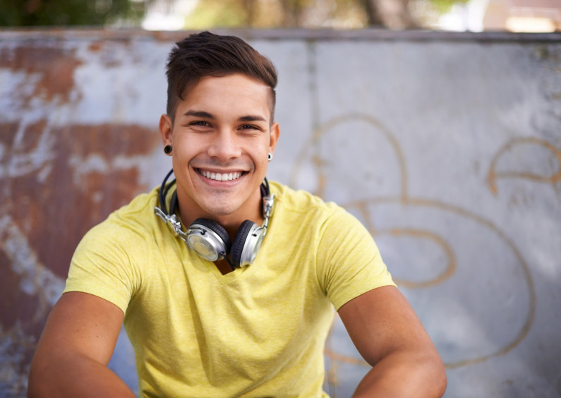 Learner sitting next to a wall and smiling