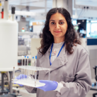 Woman holding scientific equipment stands in a laboratory