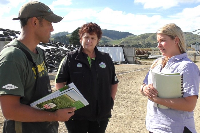 Three people on a farm talking 