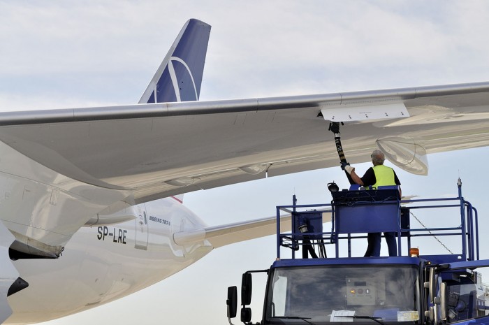 An aircraft refueller in a vehicle refuels an aeroplane on the tarmac