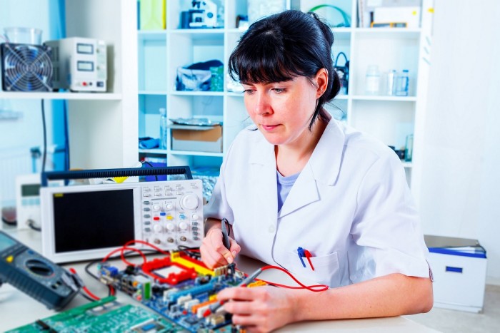 A biomedical technician tests a circuit board