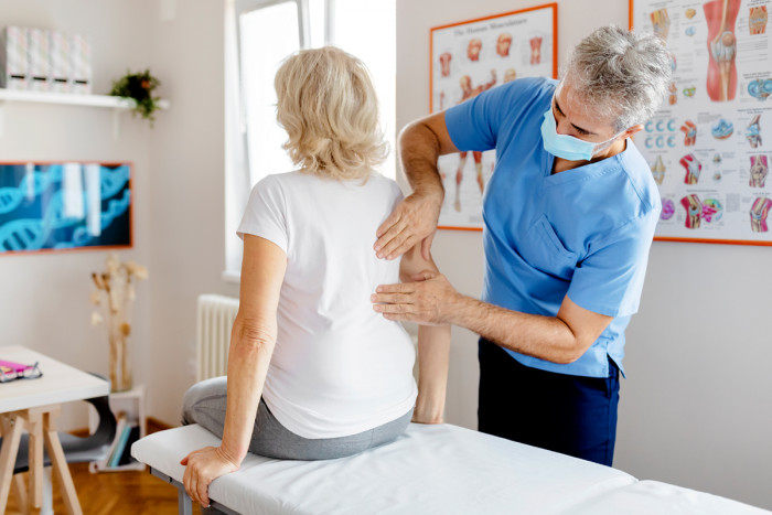 A male chiropractor examining a patient's back