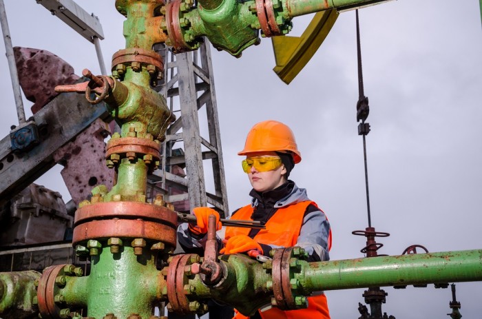 Woman performs maintenance with tools on a drilling rig