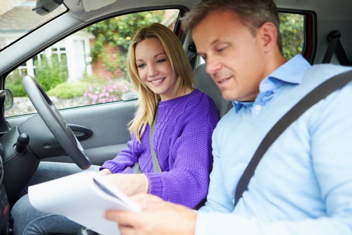 Student and driving instructor in a car