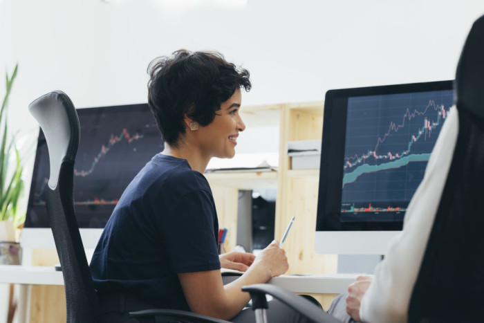 A woman studying graphs on a computer