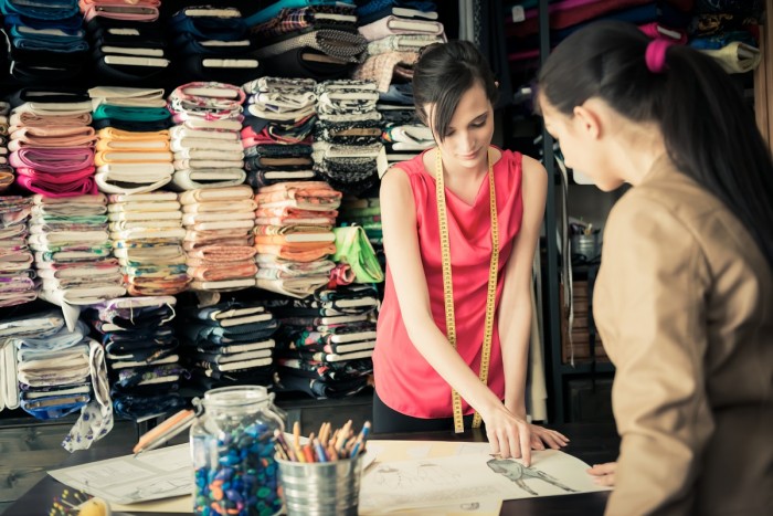 Garment technician chooses a design with a designer in a workshop
