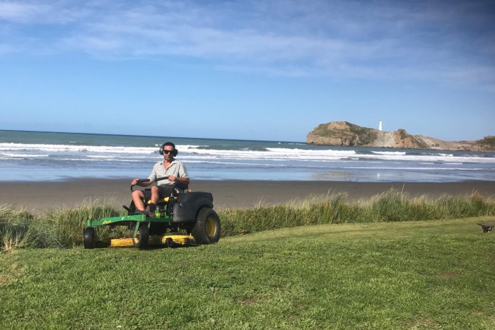 Richard Hewitt on a ride-on mower, trimming holiday park lawn