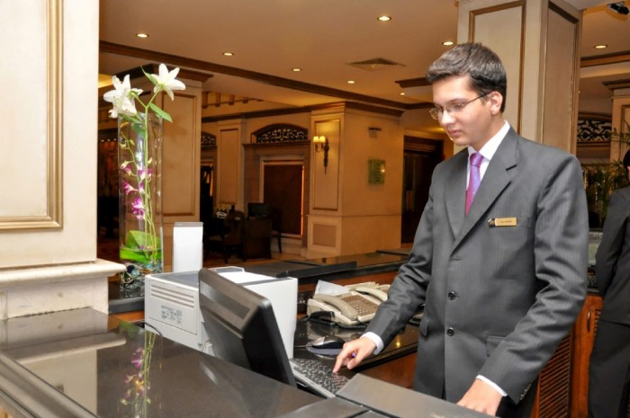 Manager on computer behind a desk at a hotel