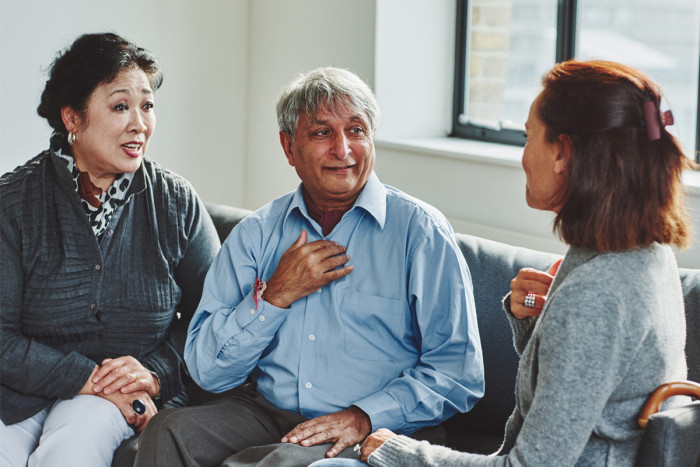 A male interpreter sitting between two women