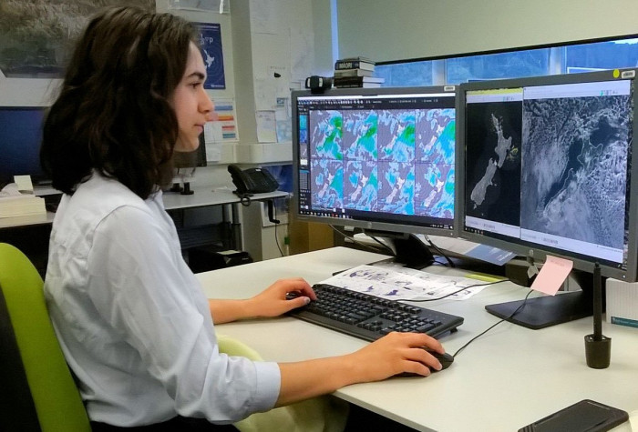 Tahlia Crabtree at her workstation looking at satellite images on computer 