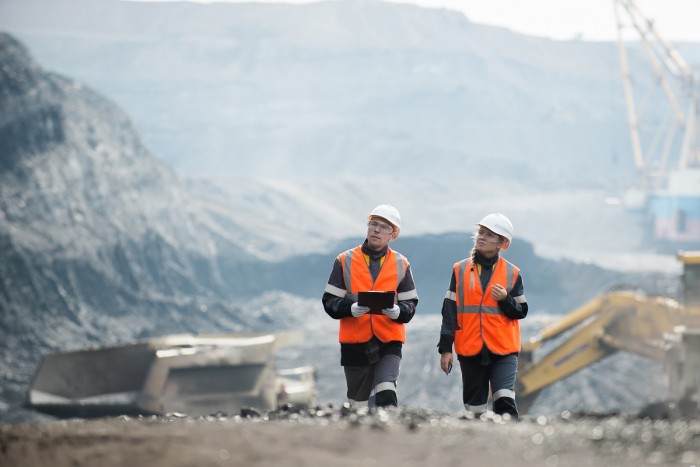 Mining engineers walk through an open cast mine to inspect it