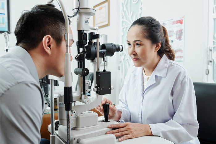 A female optometrist examining a patient's eyesight using specialist medical equipment