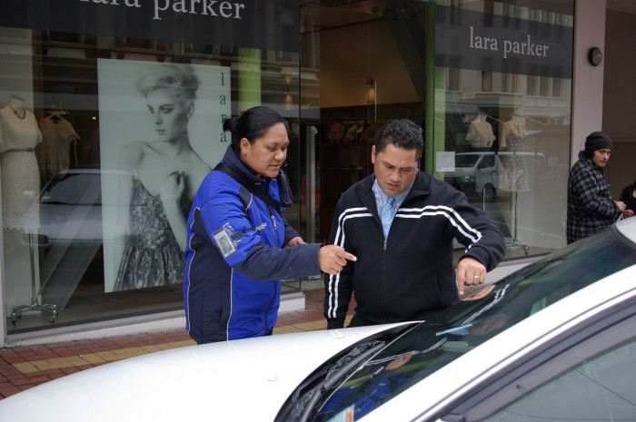 Marina Daniels and a man pointing at the windscreen of a car