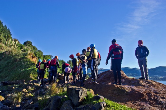 A group of people climbing rocks by the sea