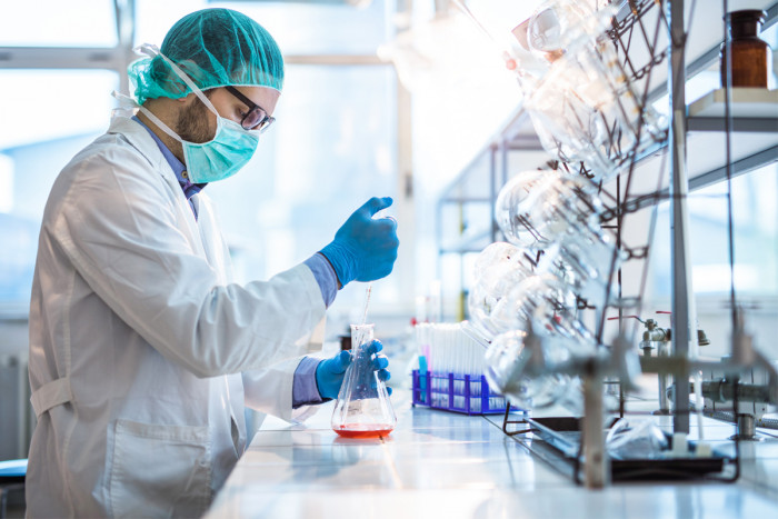 A male science technician measuring chemicals in a laboratory