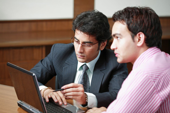 Two solicitors seated at a table, talking