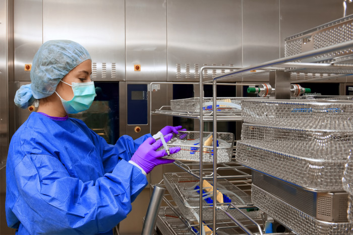 A sterilising technician cleaning surgical equipment in a hospital