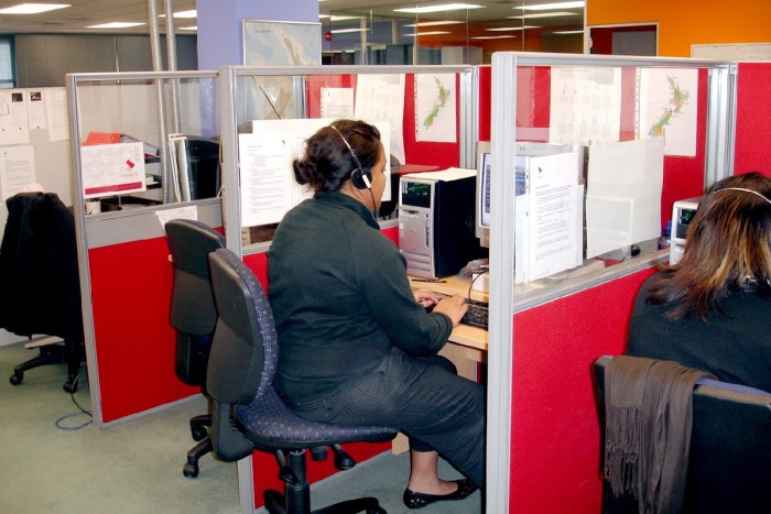 Rochelle Tapuai sitting in a booth in front of a computer wearing a headset