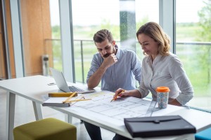 Two architects are checking blueprints