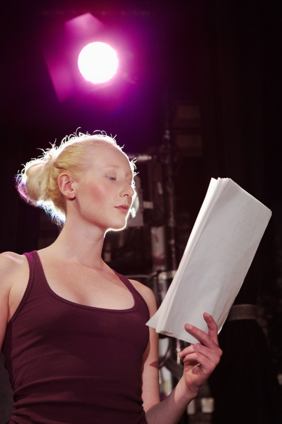 A student reads a production script on stage