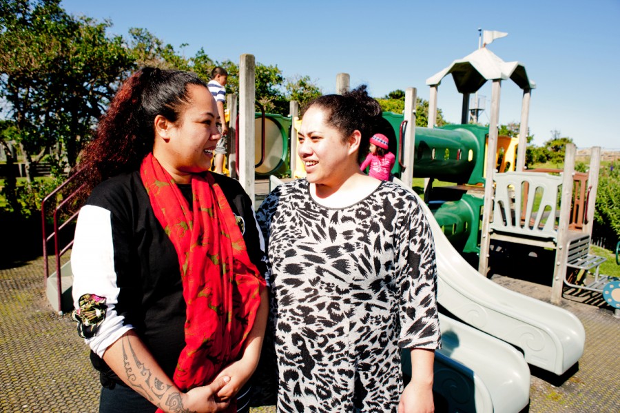 Two parents talk in a playground