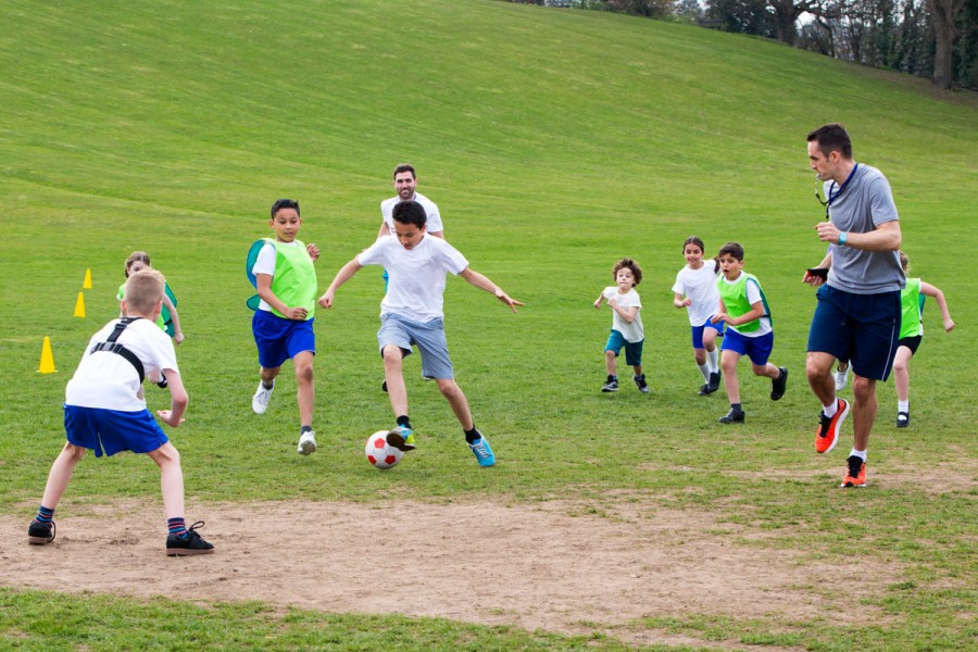 A group of primary school students play football