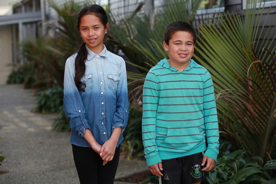 Two children stand in front of a school garden